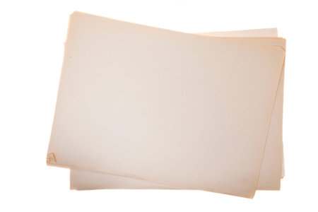 old yellowed paper on white background, several sheets are lying in an uneven pile, close-up, top...