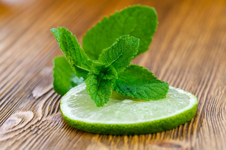 a slice of lemon with mint lying on it on a board, close-up