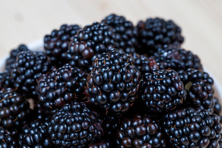 black fresh blackberries on the heap at the time of harvest, closeup