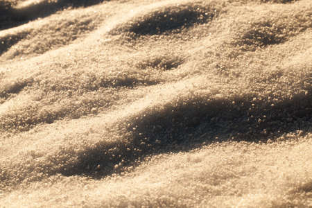winter background of snow, illuminated by sunlight and in the shade sparkling in the sun, closeupの写真素材
