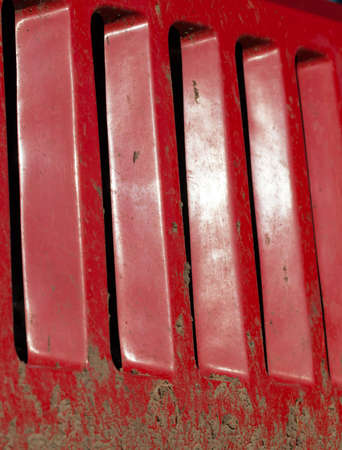 dirty and smeared in the soil part of the metal grill for protecting the engine of the tractor and its cooling, the curtain plan and details of agricultural equipment after the work in the fieldの写真素材