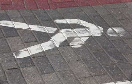 painted by white paint on the pedestrian walkway, a person who indicates who can move, part of the figure has worn off over time, a closeupの写真素材