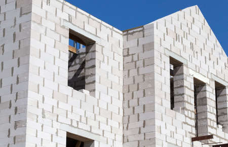 the top floor and unfinished roof constructed of white gas silicate blocks of the house for people living, a close-up of a building with windows without frames and glassesの写真素材