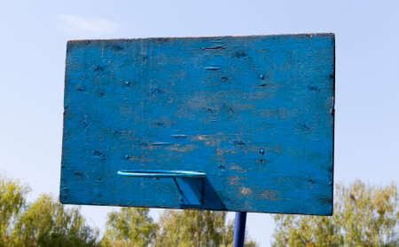 blue basketball shield of wooden sticks and a metal ring for playing basketball, countryside on a background of blue skyの写真素材