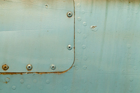 old green metal construction connected by aluminum rivets, used in aircraft building, disused...