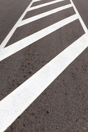 Road markings for pedestrian safety, closeup on asphalt road