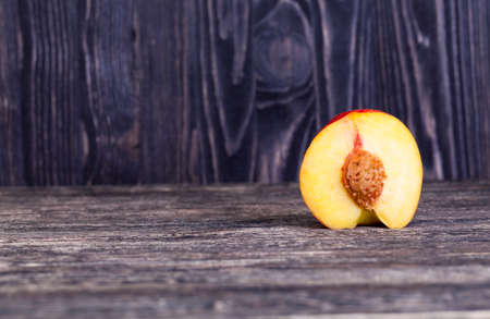 one bright red nectarine, cut into half, closeupの写真素材