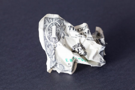 one crumpled American dollar lies on a black surface, not isolatedの写真素材