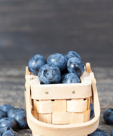 Blueberry berries and a small wooden basket, close-upの写真素材