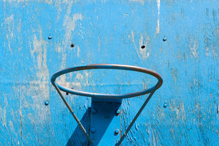 blue basketball ring on the background of a blue wooden shield on the street, closeup