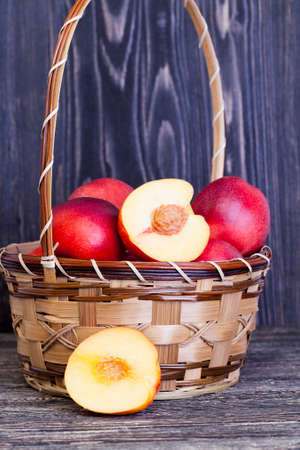 red juicy nectarines, some of which are cut into slices, closeup of food on the tableの写真素材
