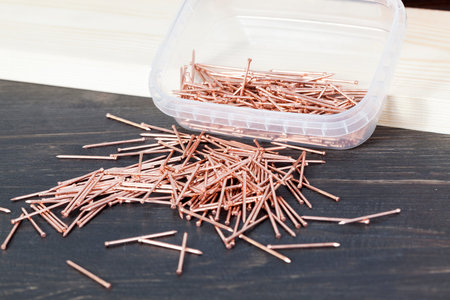 lying near the wooden board red copper nails for the finishing of wooden structuresの写真素材