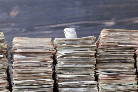 silver coins at the top of packs of old paper money, focus on coinsの写真素材