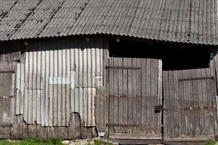 old rickety gates into a barn made of boards and logs, close-upの写真素材