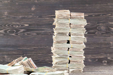 a large number of bundles of paper bills stacked on the tableの写真素材