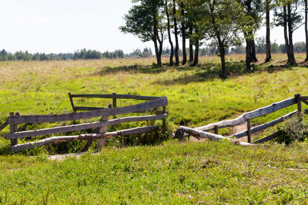 a wooden fence near the bridge over the creek, village landscapes in the summer,