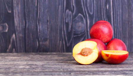 red juicy nectarines, some of which are cut into slices, closeup of food on the tableの写真素材