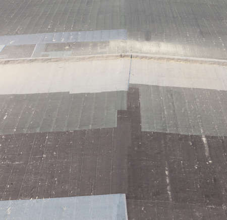 old many times repaired roof of a building of different color and shape of materials usedの写真素材