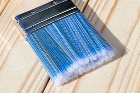 Wooden brush with a blue bristle for painting a pine wooden floorの写真素材