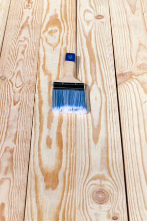 Wooden brush with a blue bristle for painting a pine wooden floorの写真素材