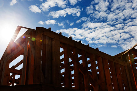 construction of a new frame house of pine planks and beams, against a blue sky, private construction of a residenceの写真素材