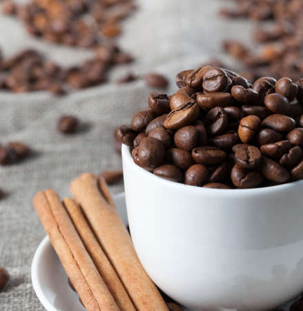 coffee beans, fragrant cinnamon sticks poured into a mug, lie along with roasted coffee, making a drinkの写真素材