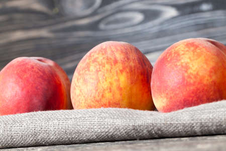a bunch of ripe large peaches, fruits are in a linen tableclothの写真素材