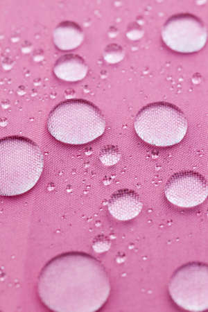 large drops of water on the water-repellent surface of the material used in the umbrella, close-upの写真素材