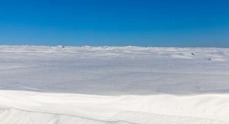 deep snowdrifts photographed close-up in sunny weather. Winter season. In the background a blue skyの写真素材