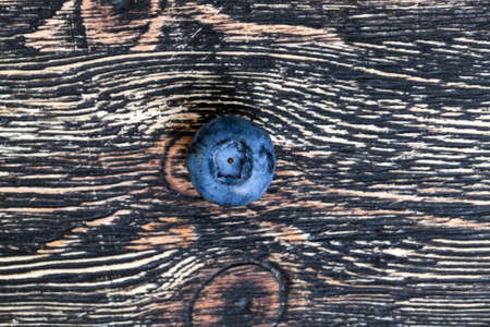 Juicy fresh blueberry berries lying on a wooden black table, closeup from aboveの写真素材