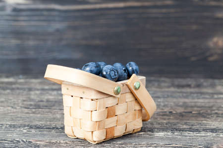 Blueberry berries lying in little wooden baskets, in the kitchen on a wooden table, countrysideの写真素材
