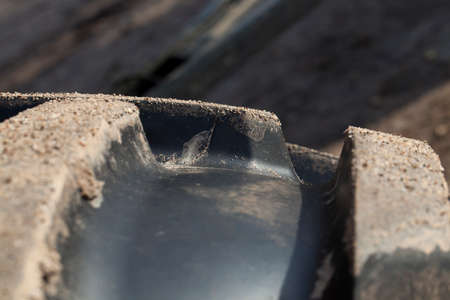 Part of the tractor s large black rubber tires is laid out in mud and sand after tillageの写真素材