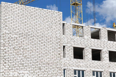 construction of a new multi-storey building of white gas silicate bricks, a multi-storey structure with residential apartments at the beginning of constructionの写真素材