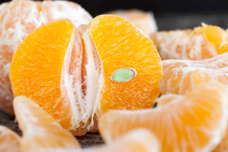 delicious tangerines, peeled orange peel lying on a wooden table, healthy citrus fruits with lots of vitaminsの写真素材