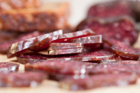 Home-made red meat sausage sliced with bread in the kitchen while preparing a large number of snacks for the holidayの写真素材