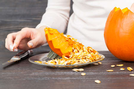 Cutting a pumpkin while preparing for the celebration of Halloweenの写真素材