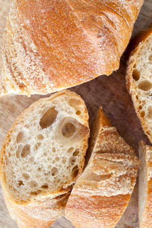 sliced long wheat baguette, close-up of food on the kitchen tableの写真素材
