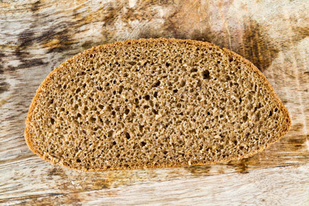 sliced loaf of black rye bread on a cutting Board, close-up of food in the village kitchen