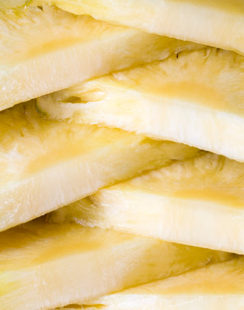 sliced piece of yellow flesh of ripe pineapple, exotic fruits, close-up