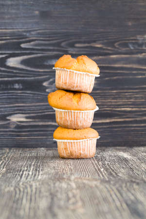 three delicious fresh wheat muffins, lie together on a black table in the kitchen, homemade pastriesの写真素材