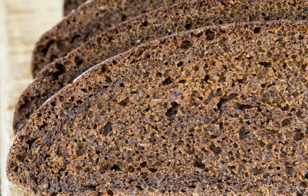 black rye bread cut in chunks on a cutting Board, close-up of traditional food in Eastern Europe