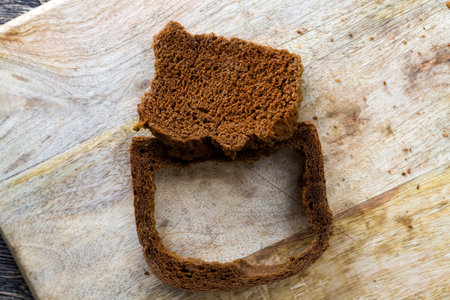 chunks of dark black bread made from rye flour, close-up of food on a wooden surface, the pulp...