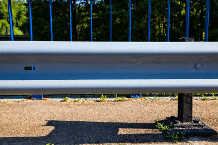 old metal barrier enclosing part of the roadway and provides safety on the road, close-up