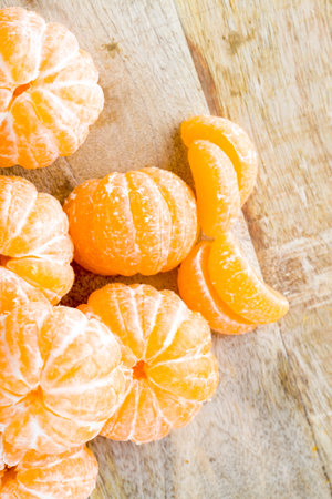 peeled orange juicy tangerine on a wooden table, close-up of ripe sour healthy citrus, winter fruitsの写真素材