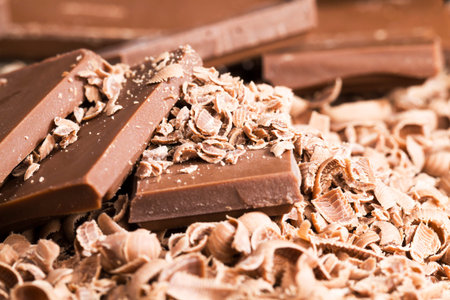 chocolate and chocolate chips on a wooden table, close-up of real chocolate made from cocoa beans...