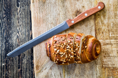 a wheat flour bun sprinkled with orange roasted peanuts, a close-up of a fresh soft bun