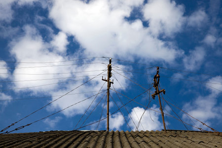 a large number of obsolete television antennas made of metal, installed on the roof of the house