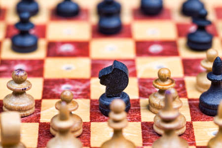 small old wooden chess pieces that can be used during trips are attached to the chessboard, chess with a little sharpness, close upの写真素材