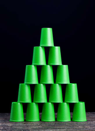 a lot of green plastic drinks cups, disposable plastic tableware, dangerous to the environment, new cups closeupの写真素材