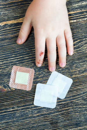 damaged one finger on the child's hand, a close-up of the hand with the damage that is already healing and being treated, a plaster is applied to the woundの写真素材